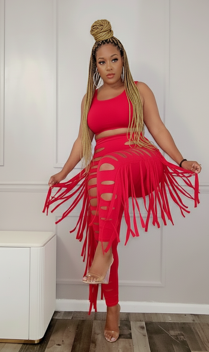 Woman wearing a red fringe outfit in a room with white walls.