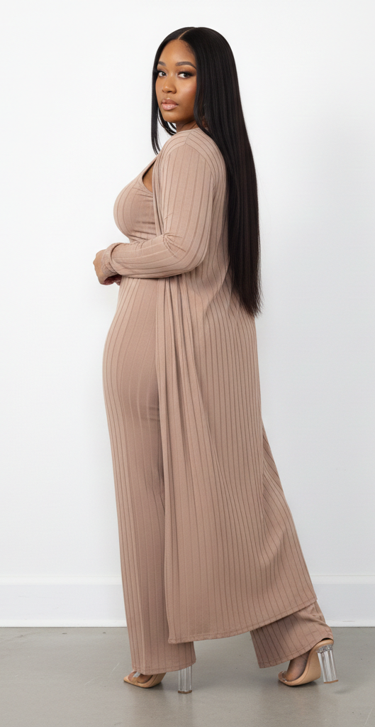 Woman wearing a long beige ribbed dress against a white background
